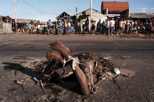 Jan 2005, Port au Prince:body of an alleged thief. He tried to still from the market just in front of him, someone cut his hand off and burned him.Lorenzo Moscia/GraziaNeri